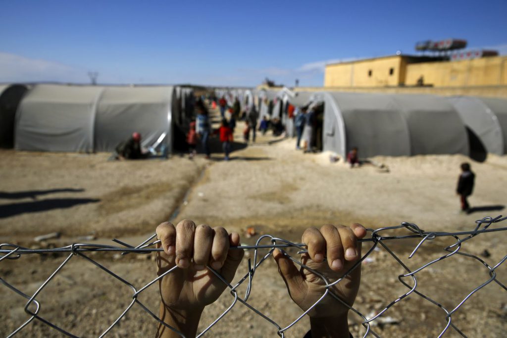 (WEB) 211716_Kurdish_refugee_boy_from_the_Syrian_town_of_Kobani_holds_onto